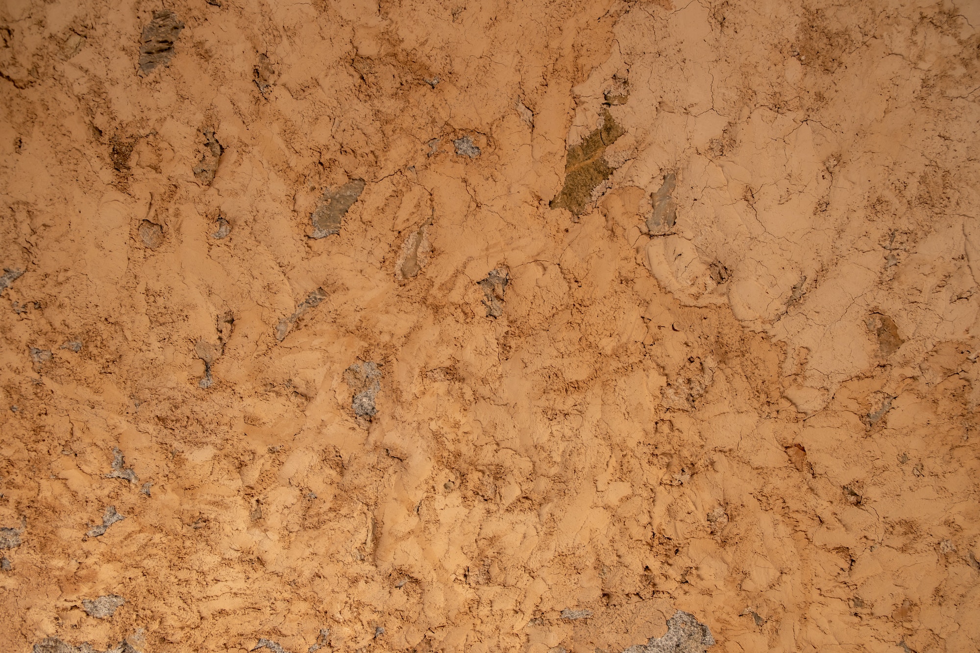 Mud plaster wall background texture. Dry brown empty soil ground, floor structure. Copy space.